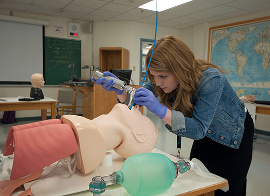 Memorial University-med student working on a medical mannequin 