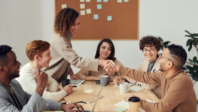 Student intern shaking hand with their colleague in the office